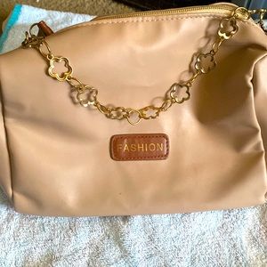 A gently used tan shoulder bag that holds a lot of stuff